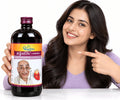 lifestyle image featuring a smiling woman holding and pointing toward a bottle of Dhootapapeshwar Arjunarishta (Parthadyarishta)